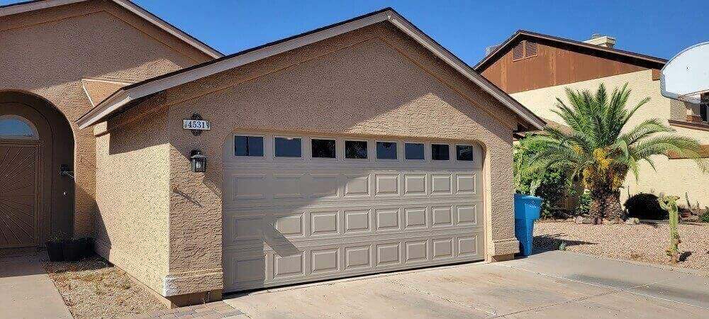 White raised-panel garage door with a row of windows on a Chandler home